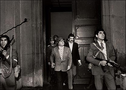 On September 11, 1973, president Salvador Allende appears shortly before his death in the presidential palace La Moneda during  Pinochet’s military coup. It is the last known image of the president, rifle in hand, determined to resist till the bitter end