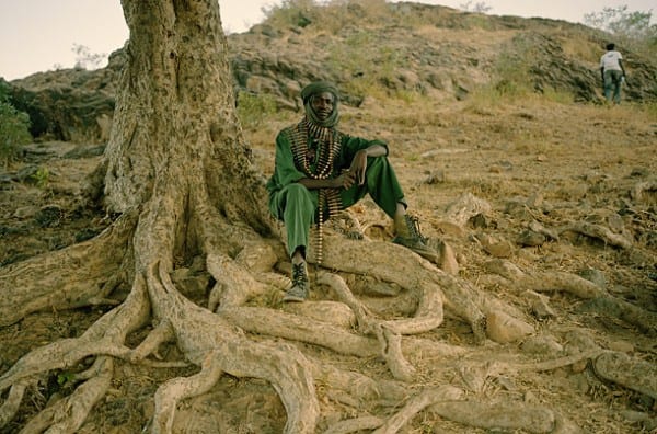 A soldier of the Sudanese Liberation Army pauses while on duty in a north Darfur town. The SLA initially rose up against government oppression. But some rebel groups are themselves responsible for the brutal atrocities against civilians. (TIME magazine.)