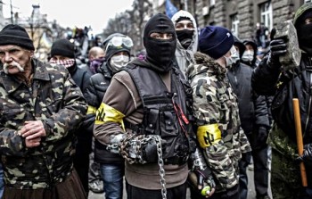 Members of the fascist "Patriots of Ukraine" organization gather for battle on the streets of Kiev, 2014. The yellow armbands display the group's symbol, a repurposed Nazi rune known as the "Wolfsangel." Photographer unknown.