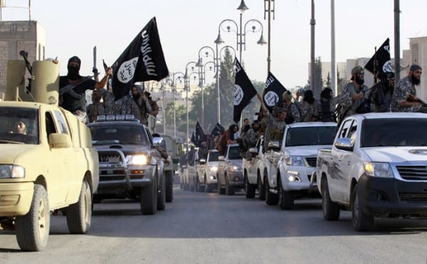 Militant Islamist fighters parade on military vehicles along the streets of northern Raqqa province
