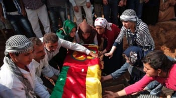 Mourners lower the coffin bearing the body of Mizgin Culbakge, a female Kurdish fighter killed in clashes with militants of the Islamic State group in Kobani, Syria, during the funeral of four female fighters, at a cemetery in Suruc, on the Turkey-Syria border, Tuesday, Oct. 14, 2014. Kobani, also known as Ayn Arab, and its surrounding areas, has been under assault by extremists of the Islamic State group since mid-September and is being defended by Kurdish fighters. (AP Photo/Lefteris Pitarakis) Close