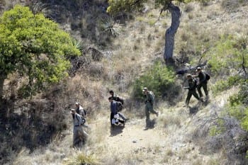 .S. Border Patrol agents escort four undocumented immigrants captured near the U.S.-Mexico border on April 23, 2015. (Defense Vids Distr. Sys.)