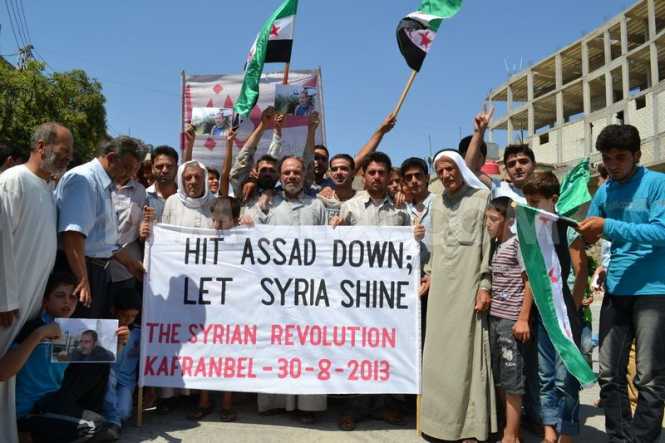 Anti-Assad rebels demonstrating in Northern Syria: Note the factory fresh flags. Who provided them?